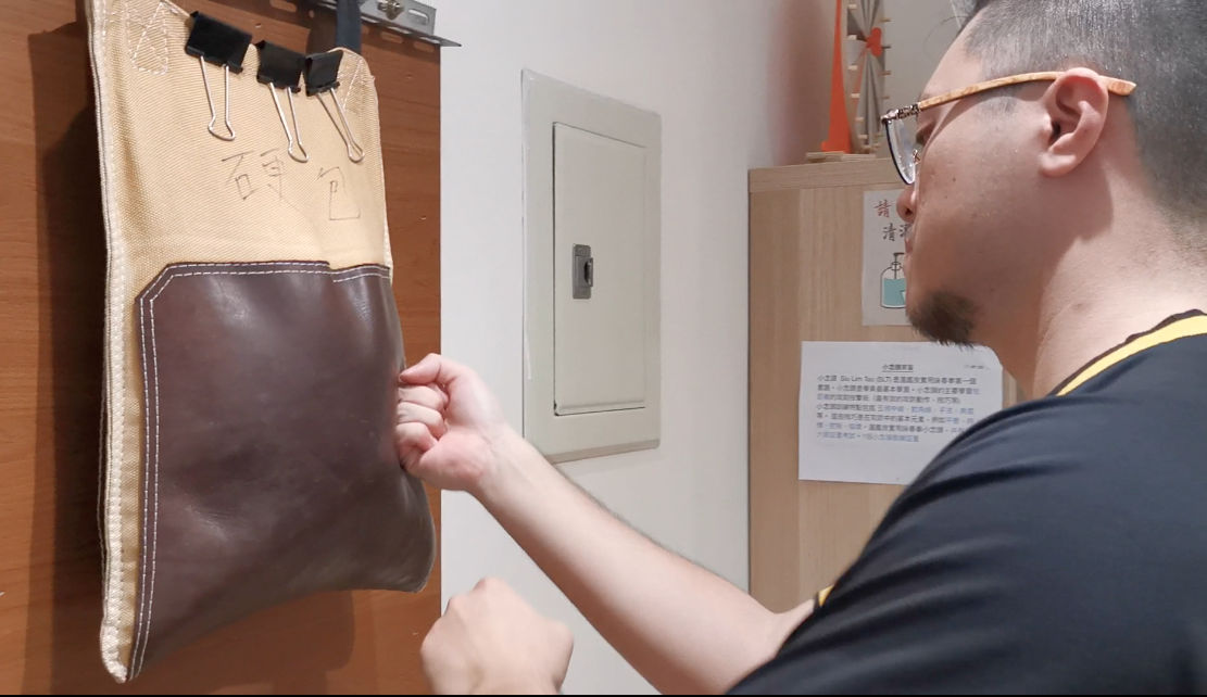 Maître Liang Qixian (梁騎顯) s'entraînant aux frappes du poing sur un sac de frappe rempli de cailloux. Crédit Photo : Ghyslain Kuehn
